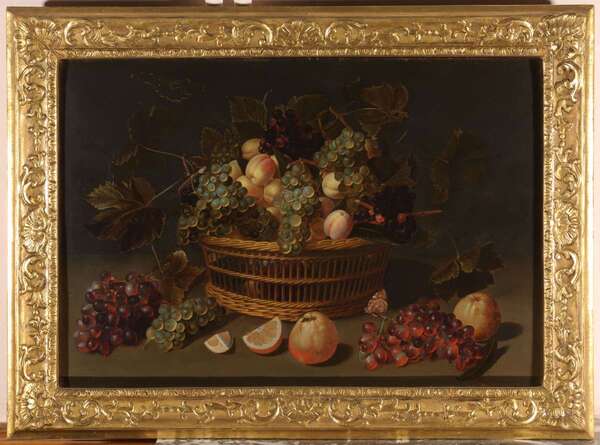 Still life with grapes, apricots, orange apple, quinces and a butterfly in a reed basket